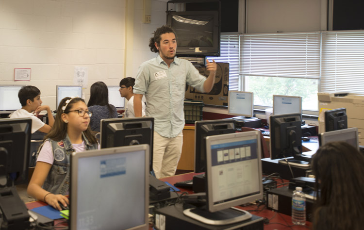 Recent graduate in game and design, Shipley Owens, uses vintage video games to help students who weren't performing well on standardized tests at Stonewall Middle School in Manassas. Photo by Jamie Rogers.